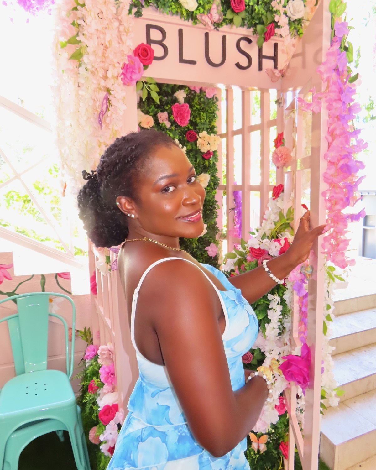 Stephanie under the pink floral archway at Blush Cafe.