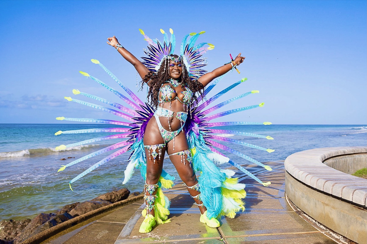 Stephanie in a feathered Crop Over costume on the seafront in Barbados.